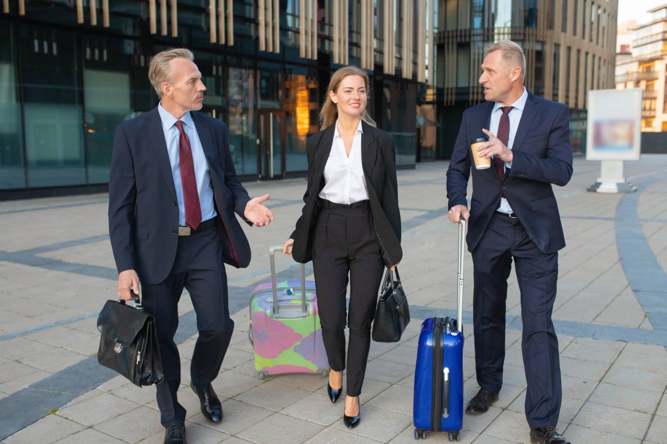 confident-businesspeople-with-luggage-walking-hotel-wheeling-suitcases-talking-full-length-front-view-business-travel-corporate-communication-concept (2).jpg